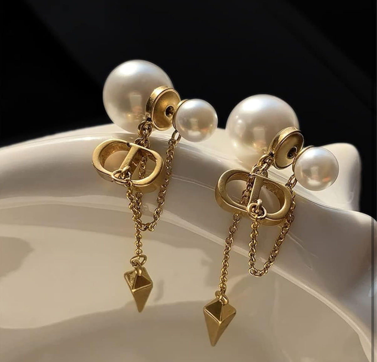 CD logo earrings with chain connect to pearl